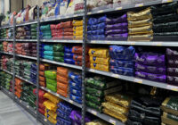 A photo of heavy-duty shelving in a corner shop, holding large bags of rice.