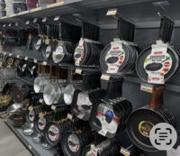A photo of various pots and pans hanging from hooks in a shop.
