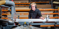 A photo of a Shelving4Shops employee working on a panel saw.